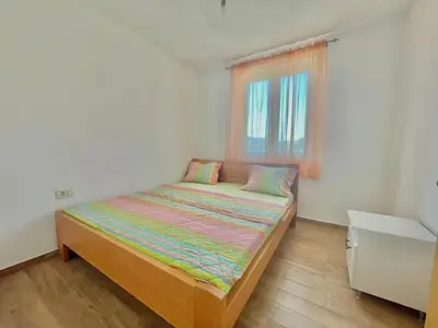 a small bedroom with a bed with a window at Talia Apartments in Budva