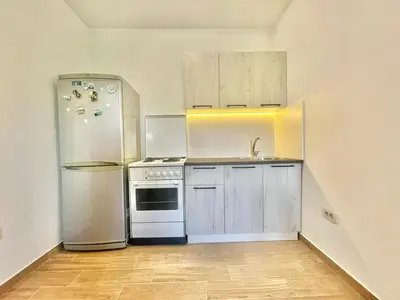 a kitchen with white cabinets and a refrigerator at Talia Apartments in Budva