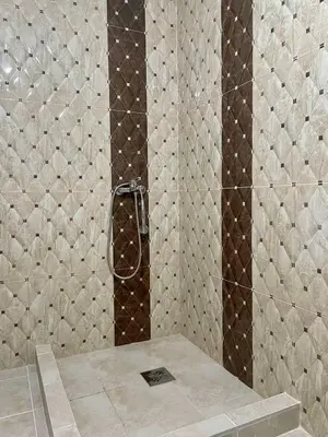 a shower with brown and white tiles in a bathroom at Talia Apartments in Budva