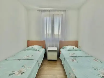 two twin beds in a room with a window at Talia Apartments in Budva