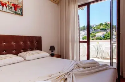 a bedroom with a large bed and a large window at Castello Apartments in Ulcinj