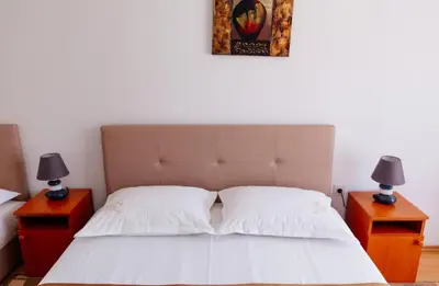 a bedroom with a bed with two nightstands and two lamps at Castello Apartments in Ulcinj
