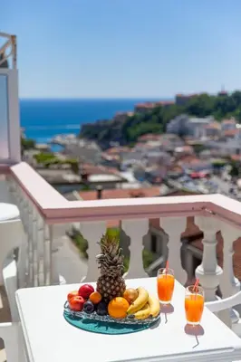 a plate of fruit on a table on a balcony at Castello Apartments in Ulcinj