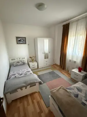 a bedroom with two beds and a rug at Large Three-Bedroom Apartment 2 Min from Airport in Podgorica