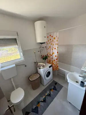 a bathroom with a toilet and a sink at Large Three-Bedroom Apartment 2 Min from Airport in Podgorica