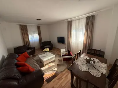 a living room with a couch and a table at Large Three-Bedroom Apartment 2 Min from Airport in Podgorica