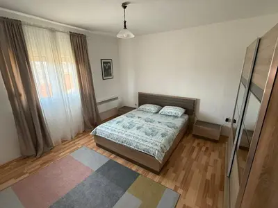 a bedroom with a bed and a rug at Large Three-Bedroom Apartment 2 Min from Airport in Podgorica