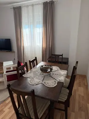 a dining room with a table and chairs in a room at Large Three-Bedroom Apartment 2 Min from Airport in Podgorica