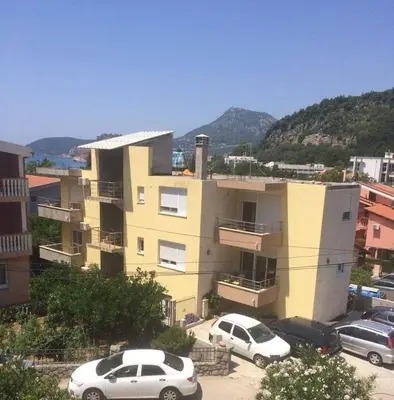 two cars parked in a parking lot in front of a building at Apartmani Vuković- Brca in Sutomore