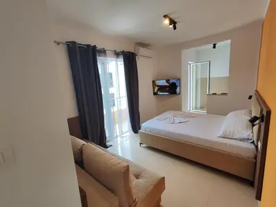 a bedroom with a bed and a couch in it at Apartmani Vuković- Brca in Sutomore