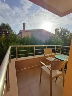 a balcony with a table and chairs and the sun at Apartmani Vuković- Brca in Sutomore