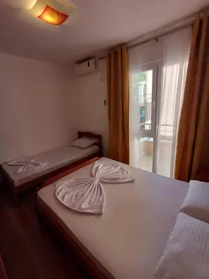 a room with two beds and a window with at Apartmani Vuković- Brca in Sutomore