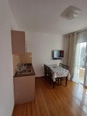 a kitchen and dining room with a table and a table and chairs at Apartmani Vuković- Brca in Sutomore