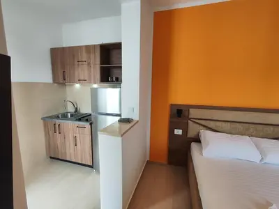 a small kitchen with a bed and a sink at Apartmani Vuković- Brca in Sutomore