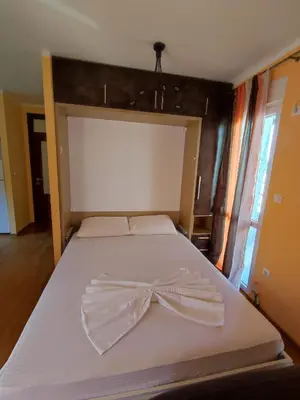 a bed with a bow tie on top of it at Apartmani Vuković- Brca in Sutomore