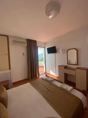 a bedroom with a bed and a dresser and a mirror at DeLux Apartmani in Dobra Voda