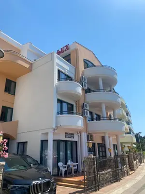 a building with a car parked in front of it at DeLux Apartmani in Dobra Voda