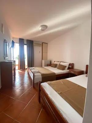 a hotel room with two beds and a television at DeLux Apartmani in Dobra Voda