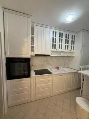 a kitchen with white cabinets and a black microwave at Apartman Na pjenu od mora Becici in Budva