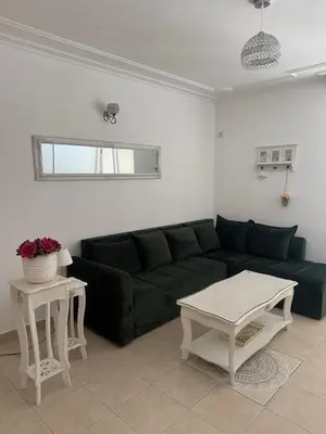 a living room with a black couch and a table at Apartman Na pjenu od mora Becici in Budva