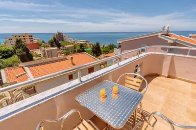 a table on a balcony with a view of the ocean at Ani Lux in Dobra Voda