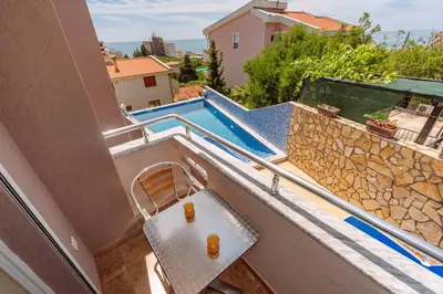 a balcony with a bench and a swimming pool at Ani Lux in Dobra Voda