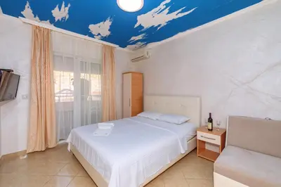 a bedroom with a white bed and a blue ceiling at Ani Lux in Dobra Voda