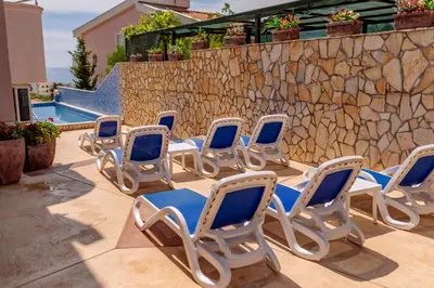 a group of chairs sitting on a patio next to a wall at Ani Lux in Dobra Voda