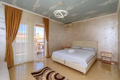 a bedroom with a bed and a room with a window at Ani Lux in Dobra Voda