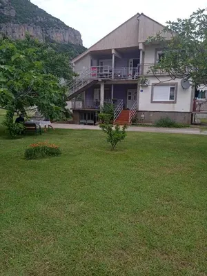 a house with a large yard with a grass field at Vila Natalija in Podgorica