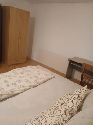 a bedroom with two beds and a table and a desk at Vila Natalija in Podgorica