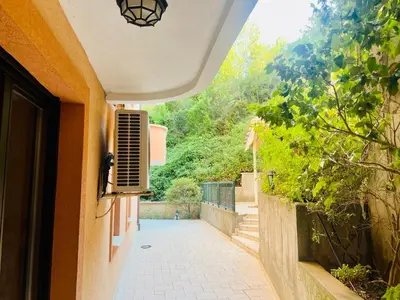 a view of a walkway from a house with a window at Jardin de fleurs in Petrovac na Moru