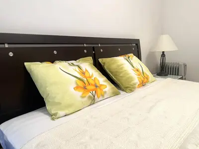 a bed with two yellow pillows on top of it at Jardin de fleurs in Petrovac na Moru