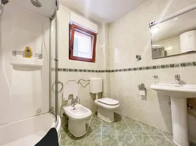 a bathroom with a toilet and a sink and a shower at Jardin de fleurs in Petrovac na Moru