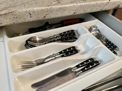 a white tray with silver utensils in a drawer at Jardin de fleurs in Petrovac na Moru