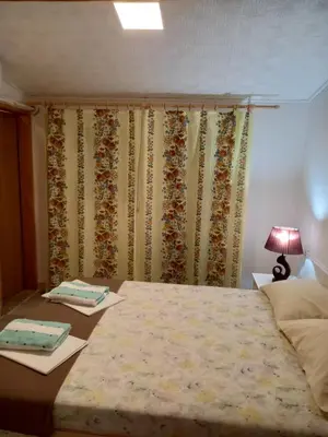 a bedroom with a bed and a table with a lamp at Bugenvilija in Budva