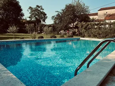 a large swimming pool with blue water at Rustic Village House 4 in Rijeka Crnojevića