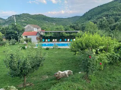 a house in a field with a swimming pool at Rustic Village House 4 in Rijeka Crnojevića