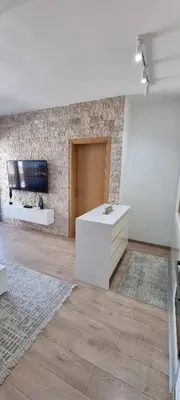 a living room with a white table and a tv at Adrijana Apartments in Ulcinj