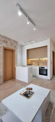 a white kitchen with a white table in a room at Adrijana Apartments in Ulcinj