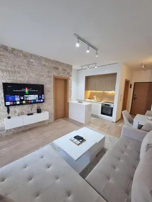 a living room with a white couch and a tv at Adrijana Apartments in Ulcinj