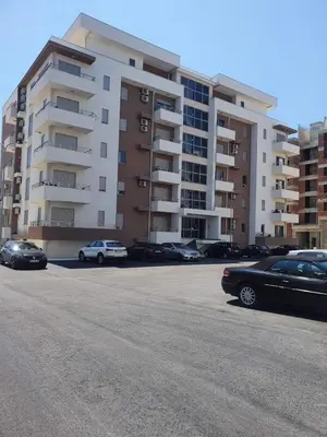 a parking lot with cars parked in front of a building at Adrijana Apartments in Ulcinj