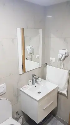 a white bathroom with a sink and a mirror at Adrijana Apartments in Ulcinj