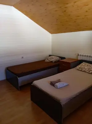 a room with two beds and a wooden ceiling at Villa Natalija in Podgorica