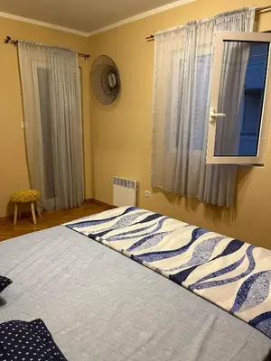 a bedroom with a large bed with a window at Apartman Nina in Kotor