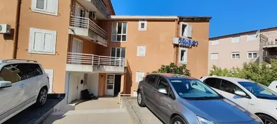 a group of cars parked in front of a building at Tomopet Apartment in Petrovac na Moru