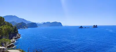 a large body of water with mountains in the background at Tomopet Apartment in Petrovac na Moru
