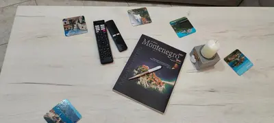 a table with a book and a remote control at Tomopet Apartment in Petrovac na Moru