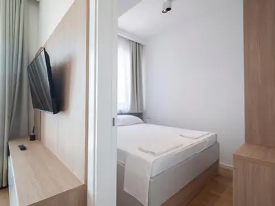a small bedroom with a bed and a tv at Horizon one bedroom apartment NS in Becici