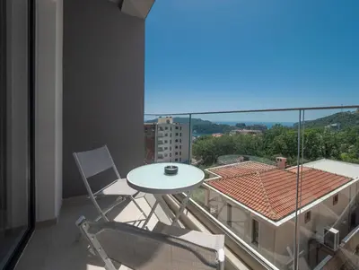 a balcony with a table and chairs and a view at Horizon one bedroom apartment NS in Becici